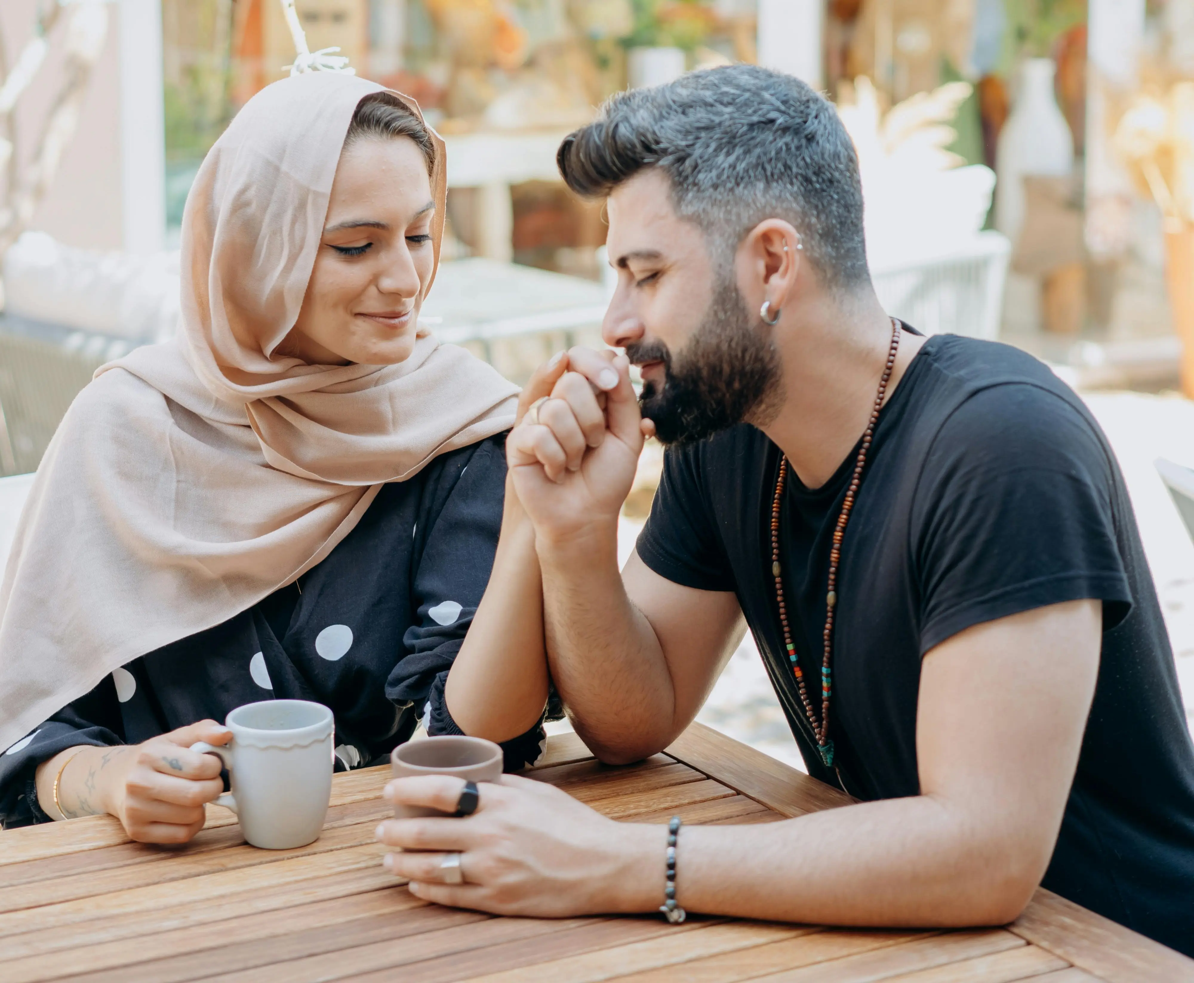 A couple shares a cup of coffee outdoors.