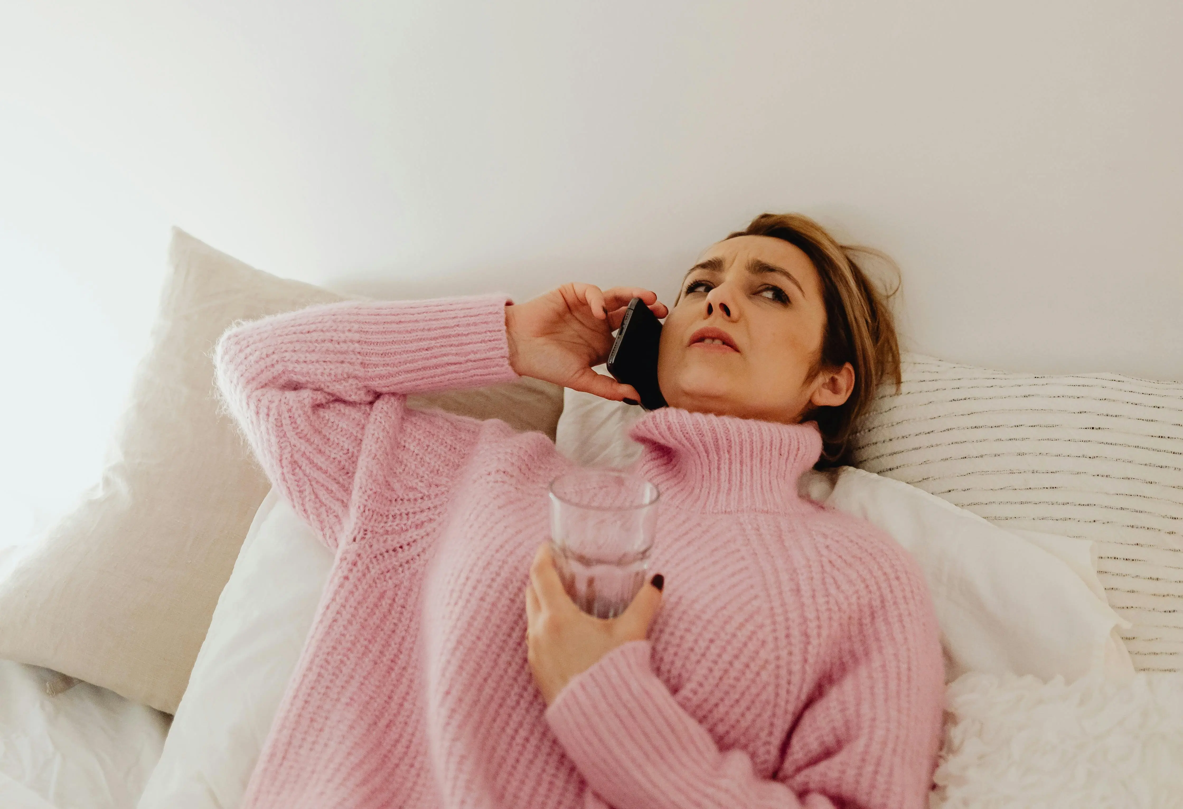 A woman is on the phone, with a suspicious expression on her face.