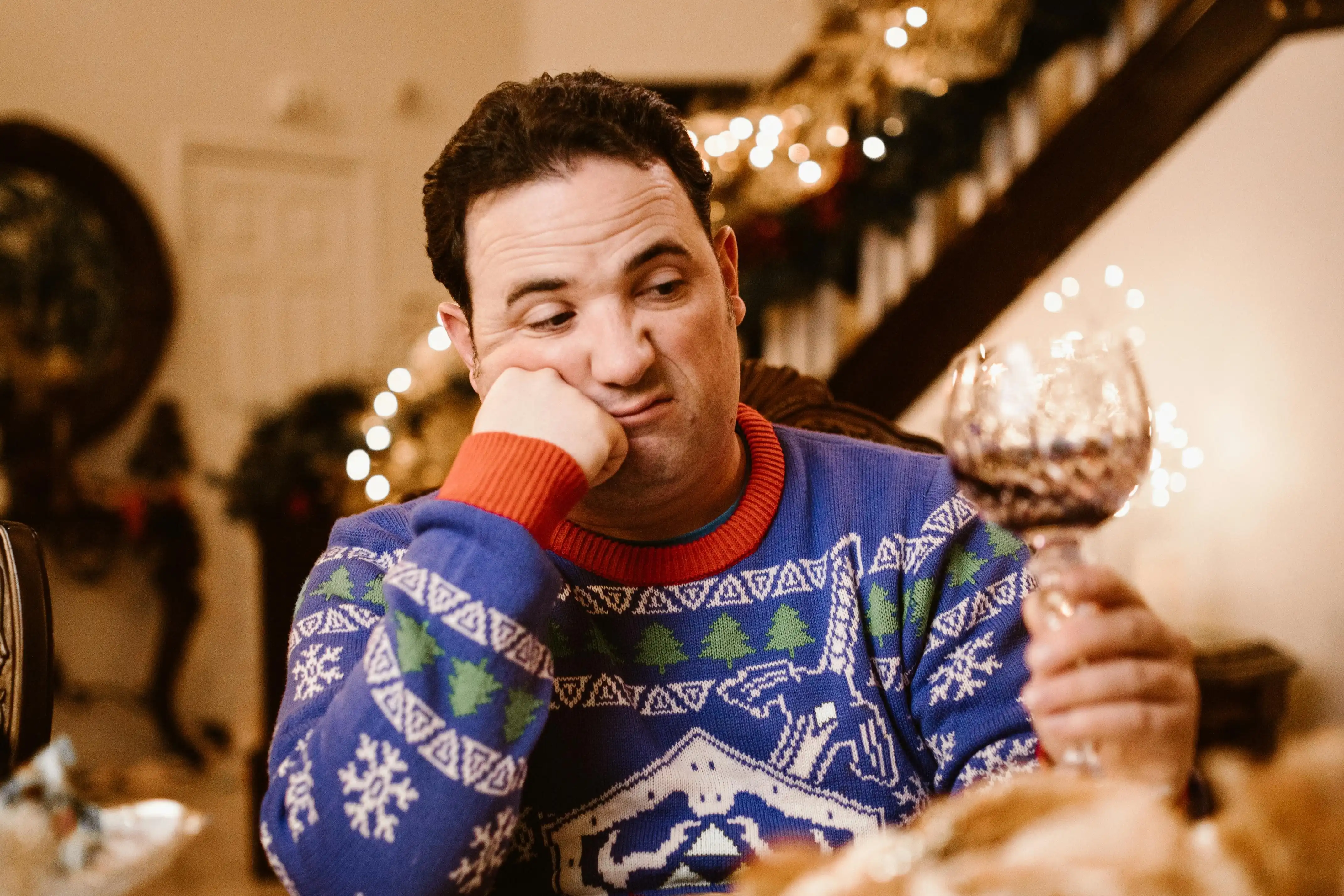 A man drinking wine alone during Christmas.