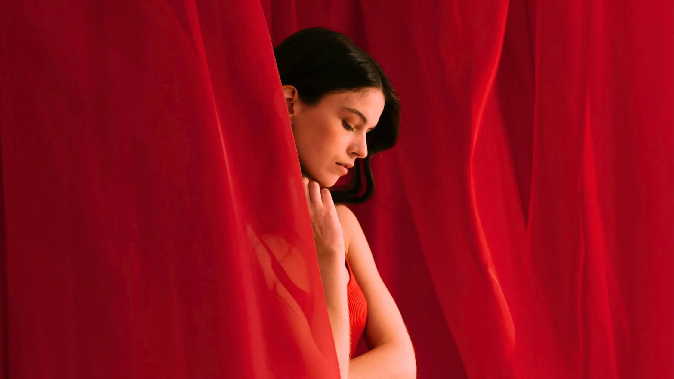 A woman surrounded by red fabric