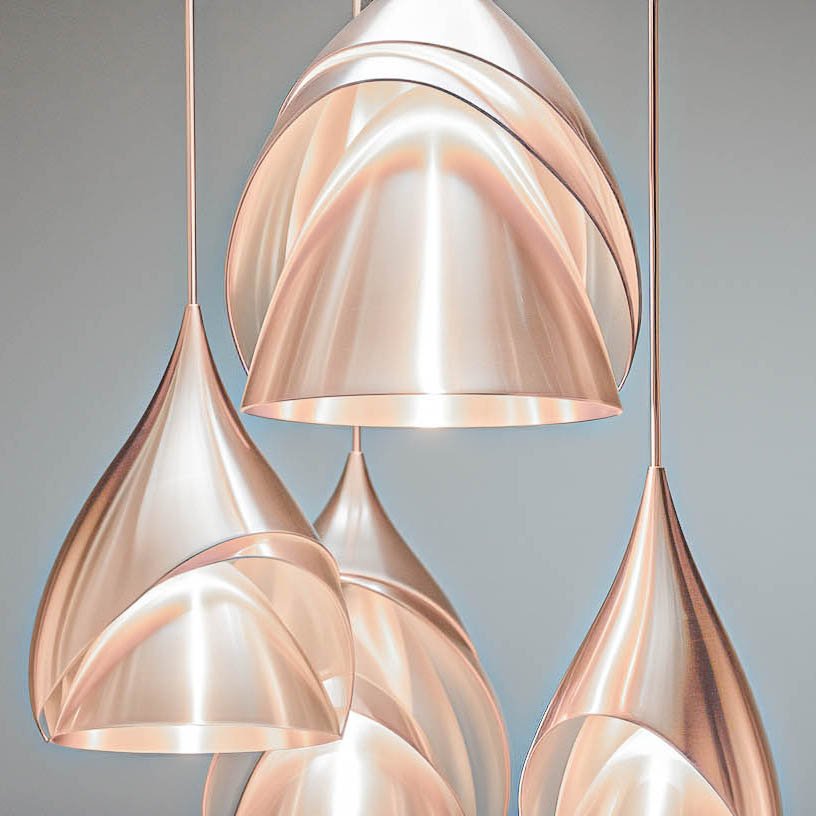 Moderne Pendelleuchten in Form von geschwungenen Tropfen aus glänzendem Metall, die eine elegante und zeitgenössische Beleuchtungslösung bieten. Ideal für stilvolle Innenräume.