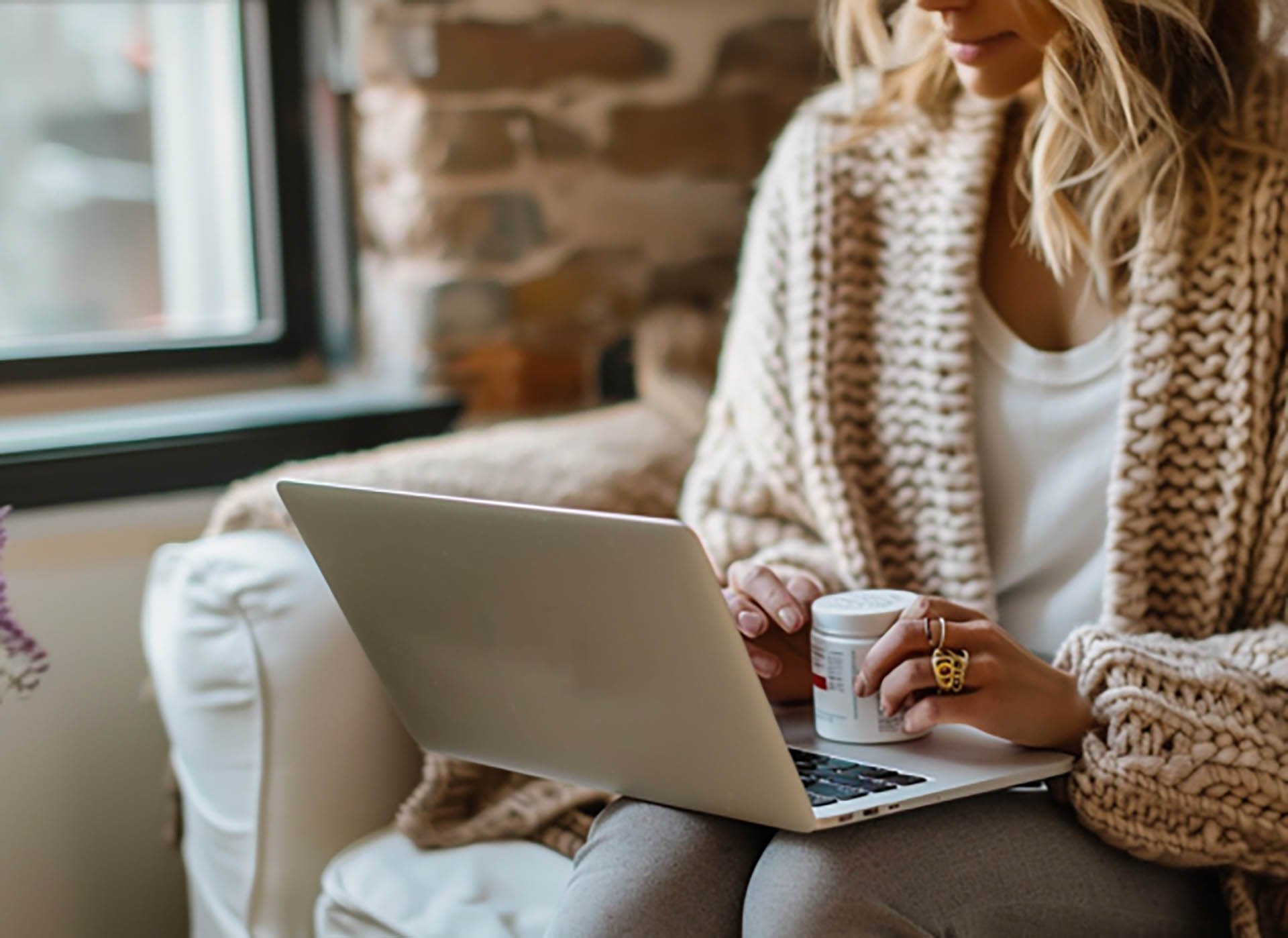 Frau mit Notebook am Sofa