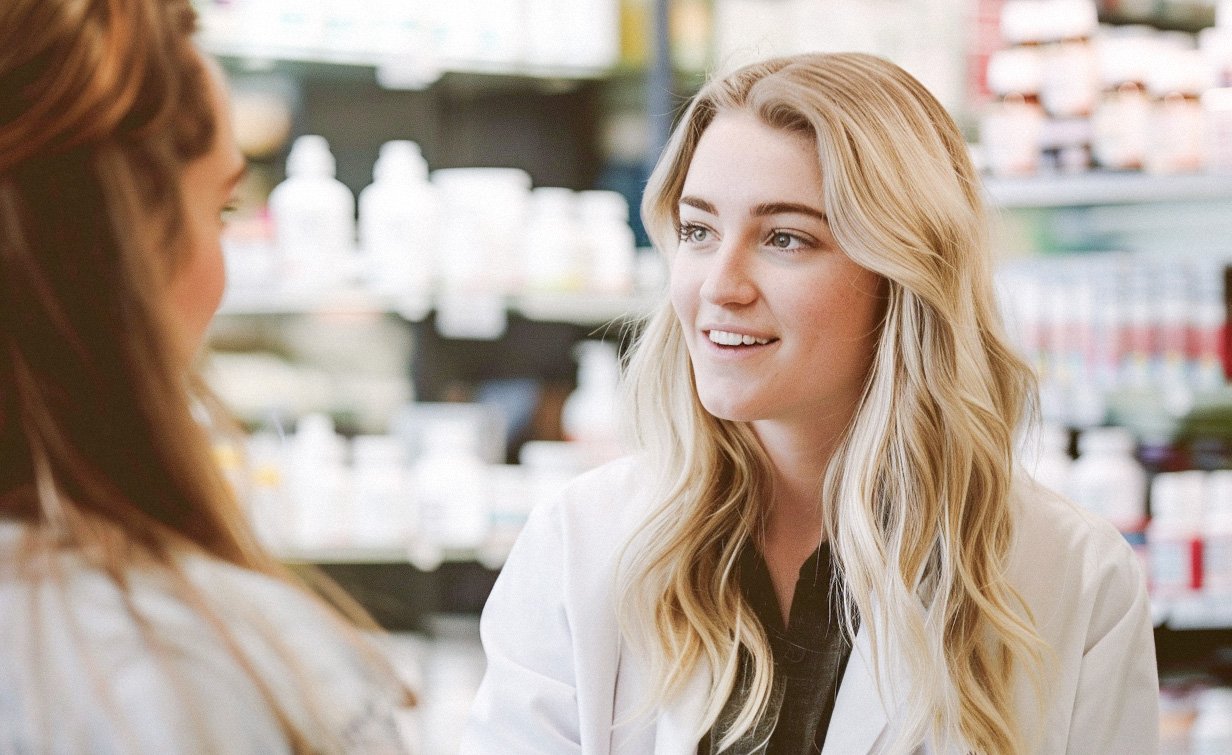 Apothekerin spricht mit Kunde an der Tara