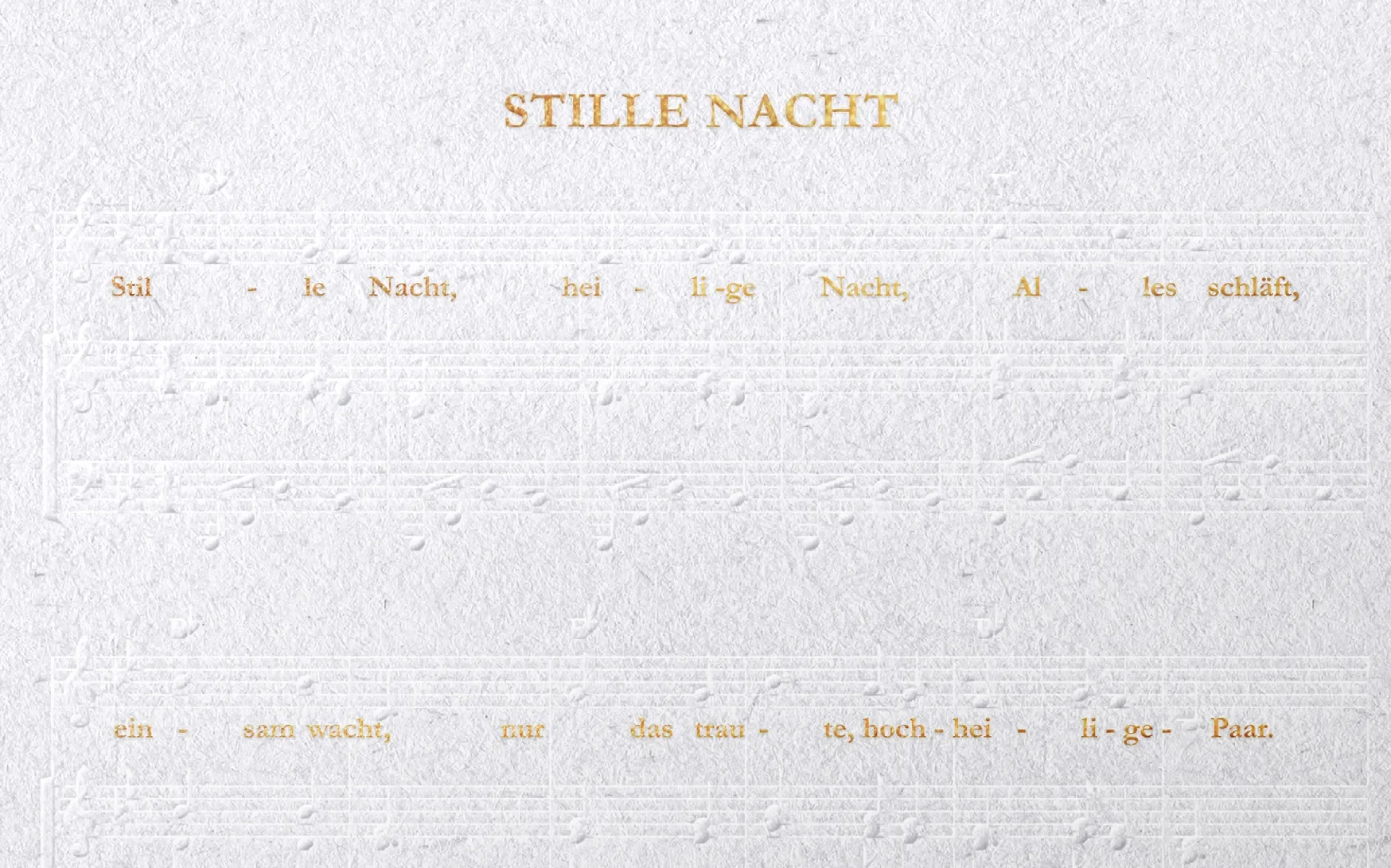 Ein Blatt mit dem Titel "Stille Nacht" in goldener Schrift, das die ersten Zeilen des bekannten Weihnachtsliedes zeigt, umgeben von einem strukturierten, hellen Hintergrund.