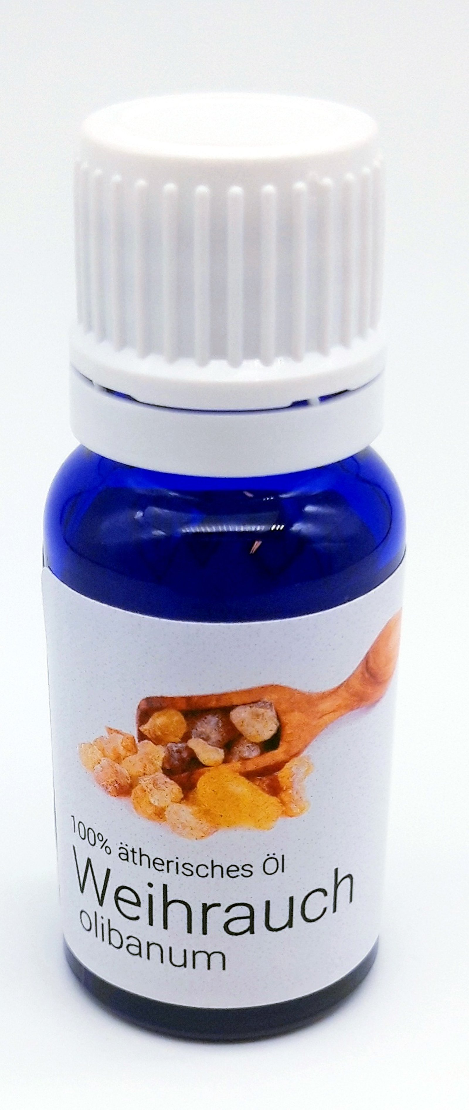 Flasche mit 100% ätherischem Öl Weihrauch (Olibanum) und Holzlöffel mit Harzstücken.