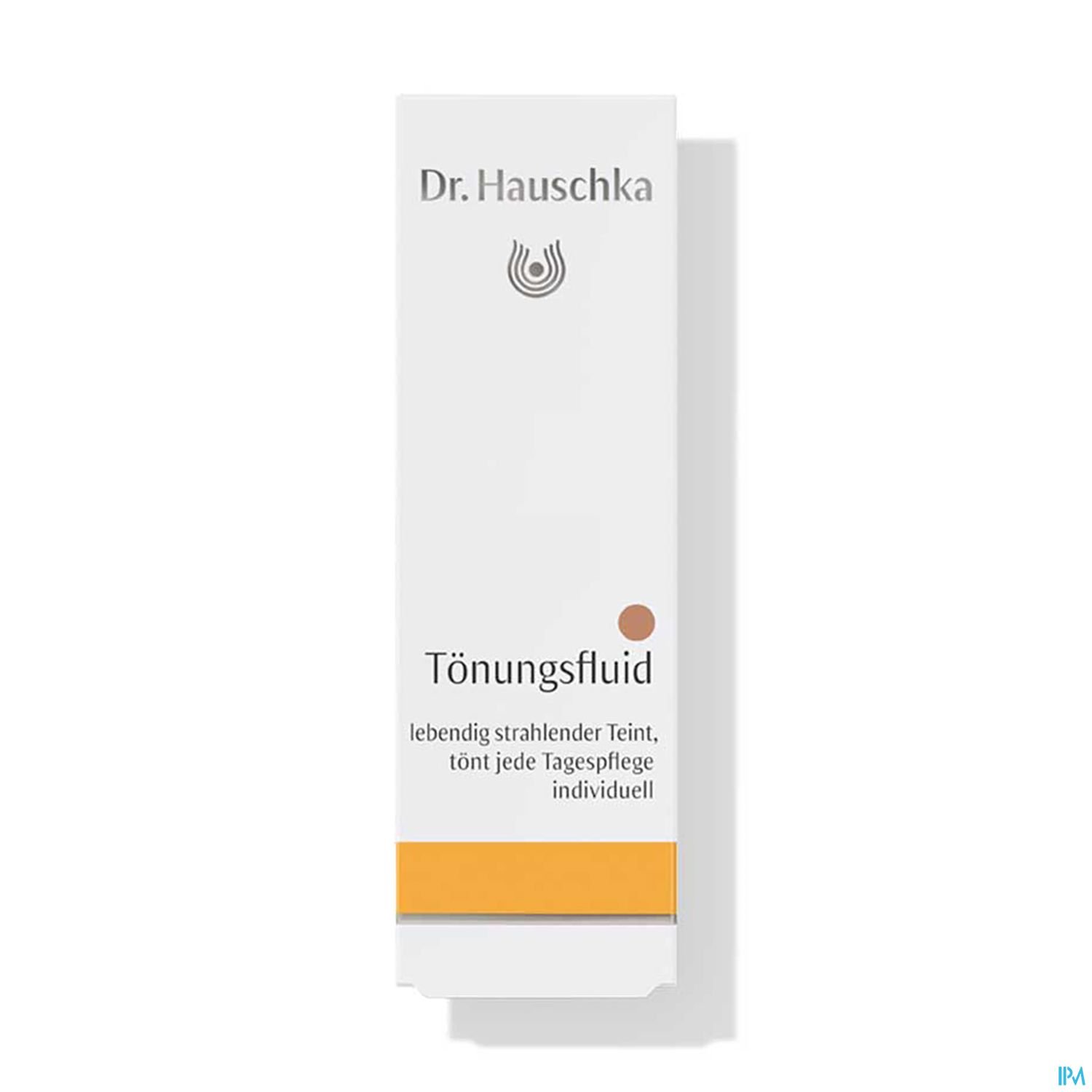 Produktverpackung von Dr. Hauschka Tönungsfluid, weiß mit orangefarbenem Akzent und Text.