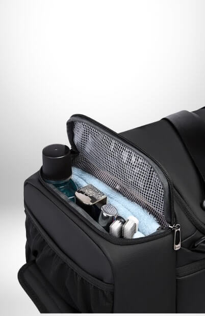 Un gros plan d'un grand sac sport noir ouvert avec des articles de toilette à l'intérieur.