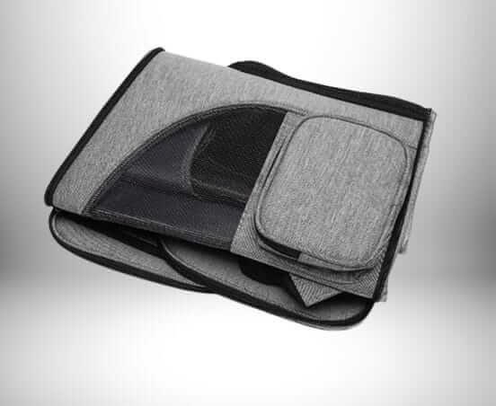 Un sac a dos transport chat gris plié avec un rembourrage et un filet noir.