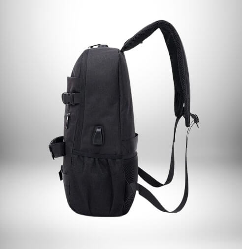 Un sac à dos noir, probablement un sac à dos skate, posant sur un fond blanc. Le sac à dos a une sangle rembourrée, des boucles et des poches.