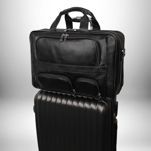 Un sacoche medecin noire est posée sur une valise noire. Les deux sont sur un arrière-plan gris.