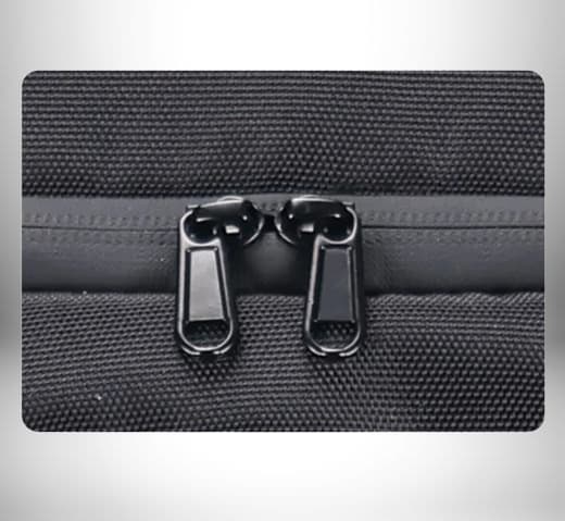 Gros plan sur deux fermetures à glissière d'un sac dos isotherme noir.\n
