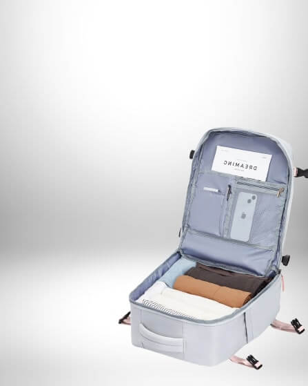Un petit bagage easyjet gris est ouvert, révélant des vêtements emballés et un compartiment de rangement avec un téléphone et une carte.