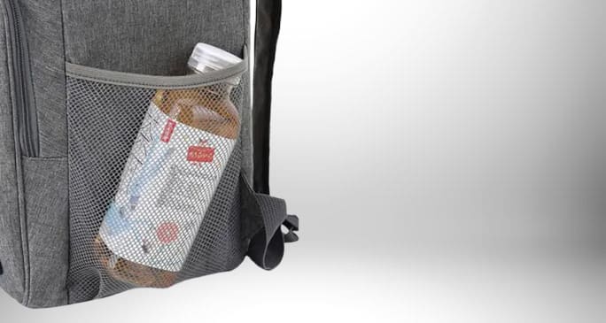 Image d'un sac à dos isotherme travail gris avec une bouteille de thé glacé dans une poche latérale en filet.