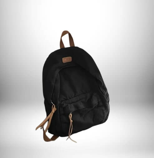 Sac à dos en coton noir avec détails en similicuir marron, style classique sur fond blanc dégradé
