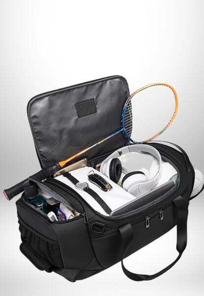 Un grand sac sport noir avec une raquette de badminton, un casque, une montre de poignet, un jeu de clés et d'autres accessoires à l'intérieur.