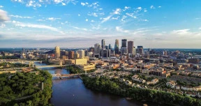 An aerial photo of downtown Minneapolis, MN beyond the Mississippi River.