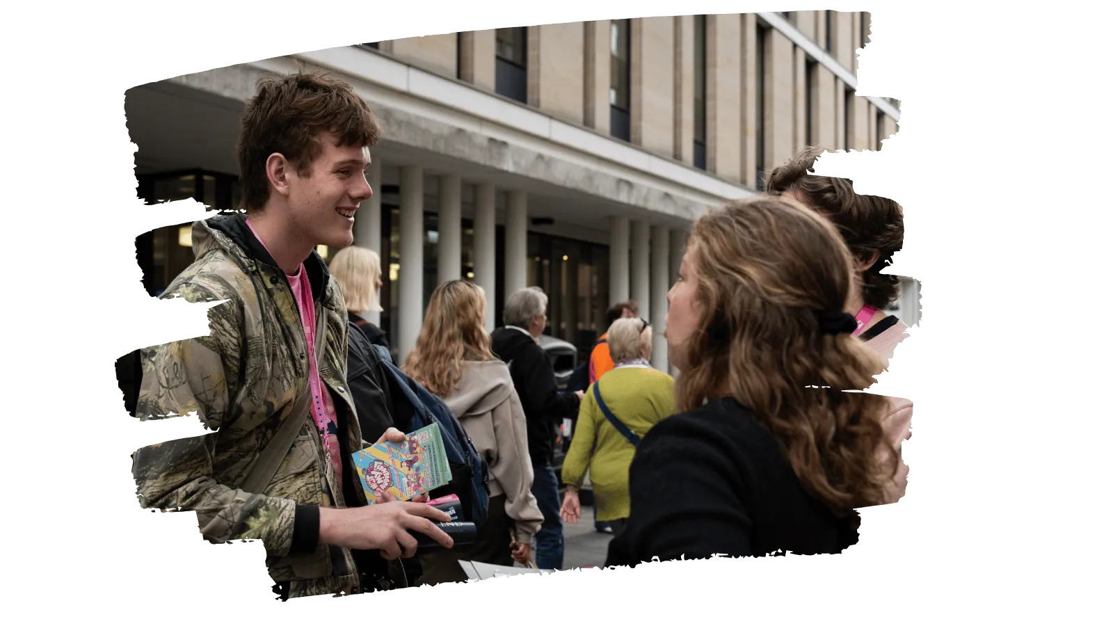 A tall man handing out flyers. He has a lovely smile