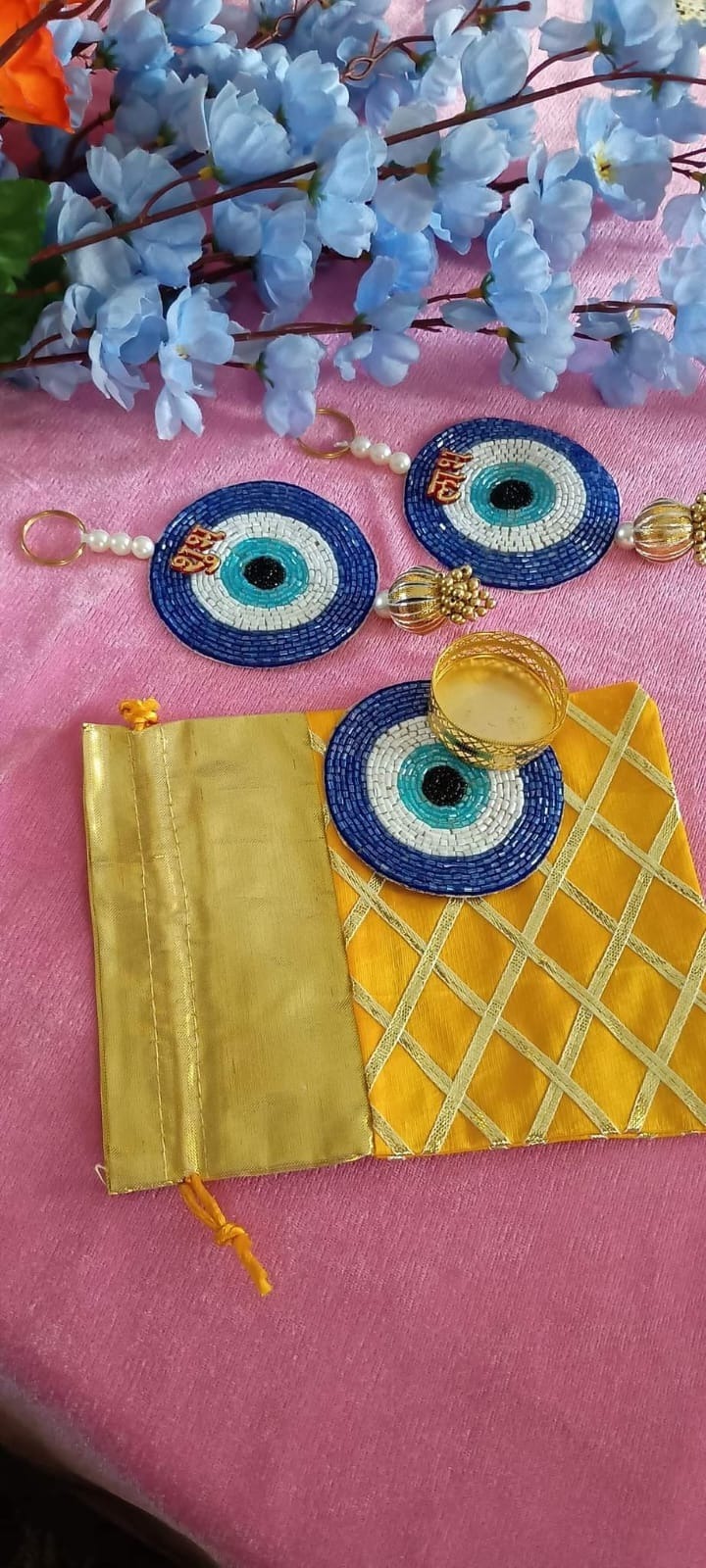 Evil eye shubh labh pair plus tealight combo in a net tissue potli (  Pls note no brocade potli). Evil eye color pink, red or yellow colour available  Potli color random