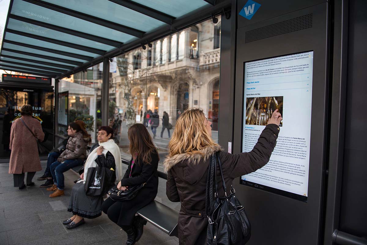 A woman reads a digital display in a train station
