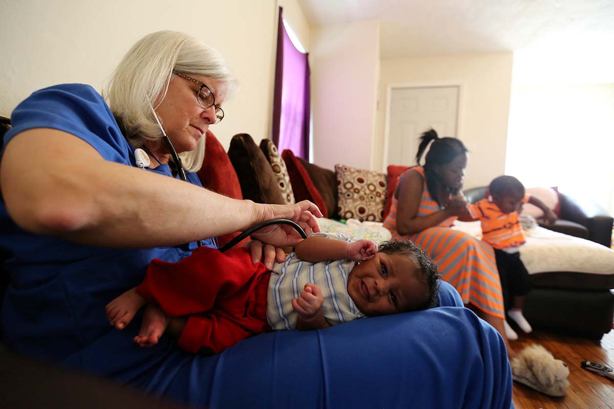 A registered nurse examines an infant