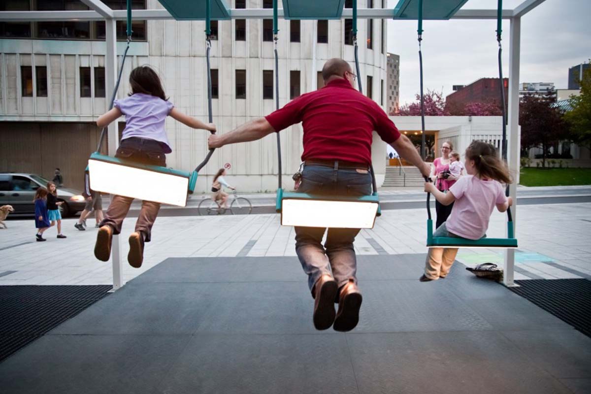 A family plays on a swing set