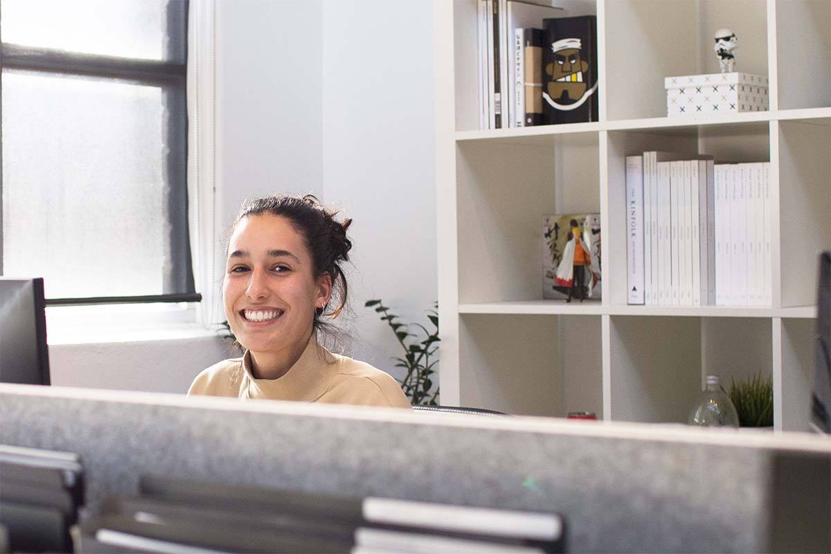 A woman smiles at her office desk