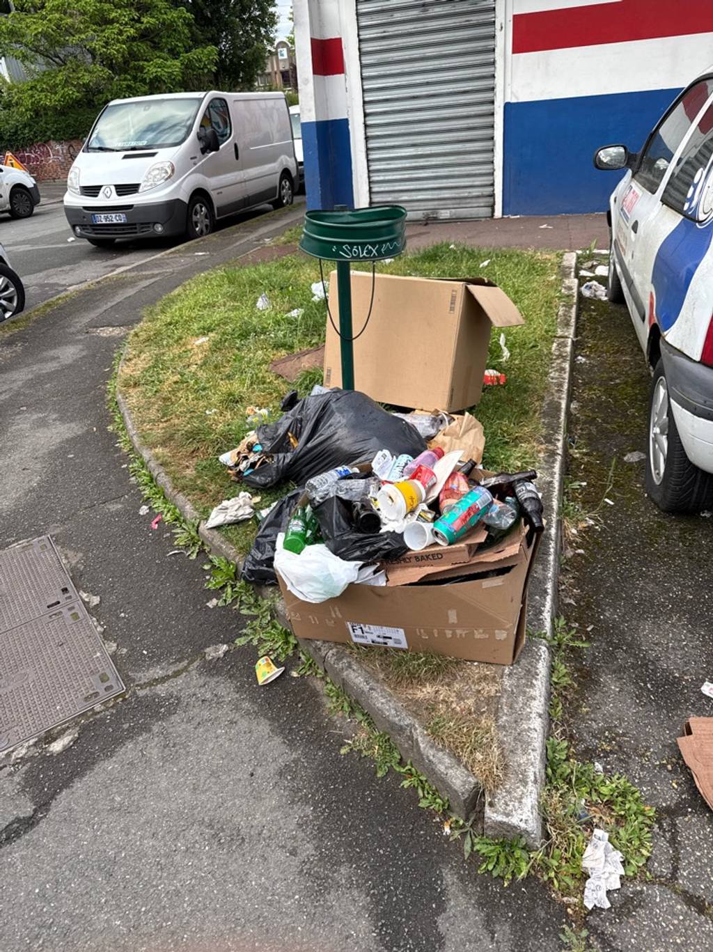 Poubelle cassée, déchets au sol.