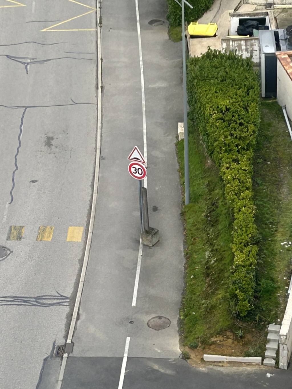 Poteaux de béton obstruant piste cyclable.