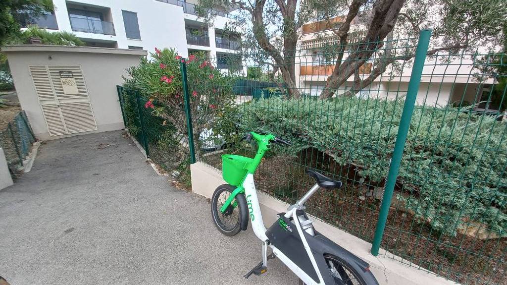 Vélo location abandonné devant transformateur résidence.
