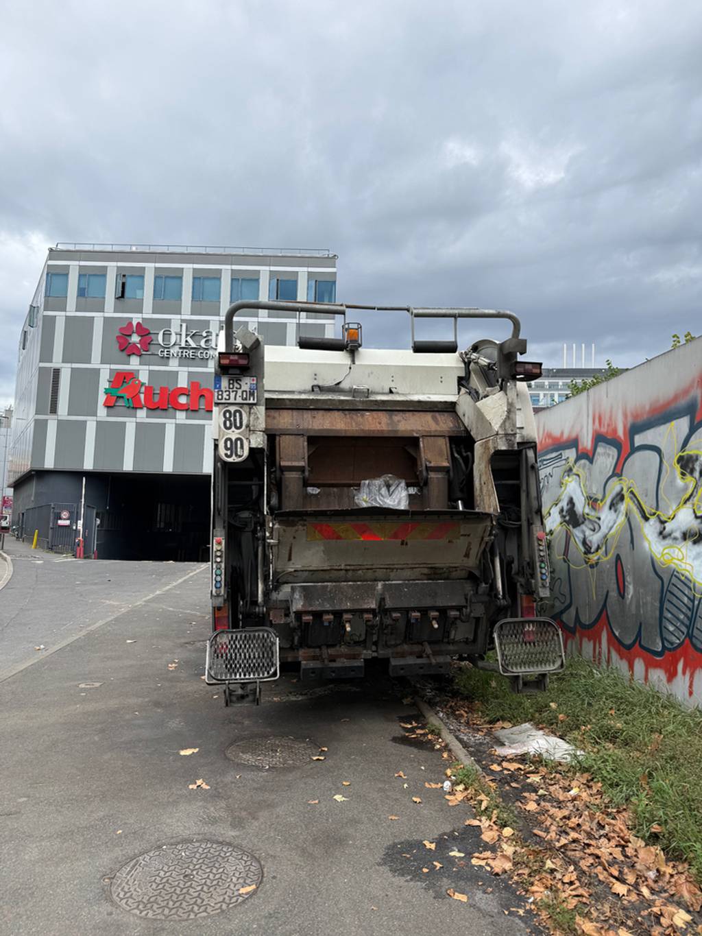 Camion poubelle stationné devant entrée livraisons.