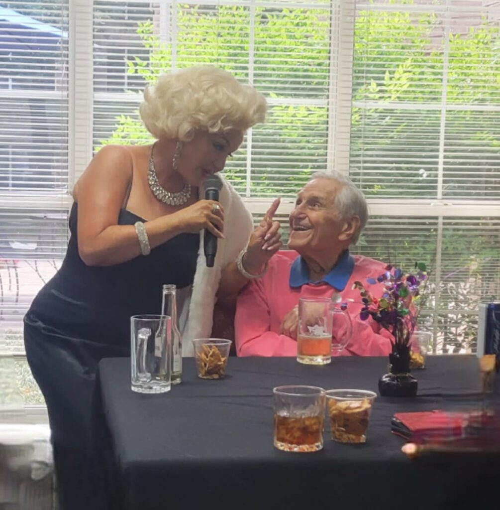 A Marilyn Monroe impressionist performer sings to a senior resident.