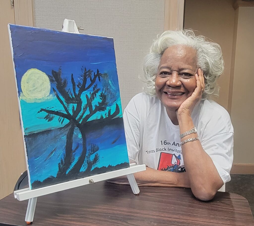 A senior resident poses with her canvas painting.