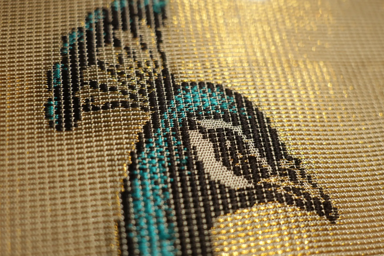 Peacock head and neck woven in turquoise and black silk on a shimmering gold zari ground