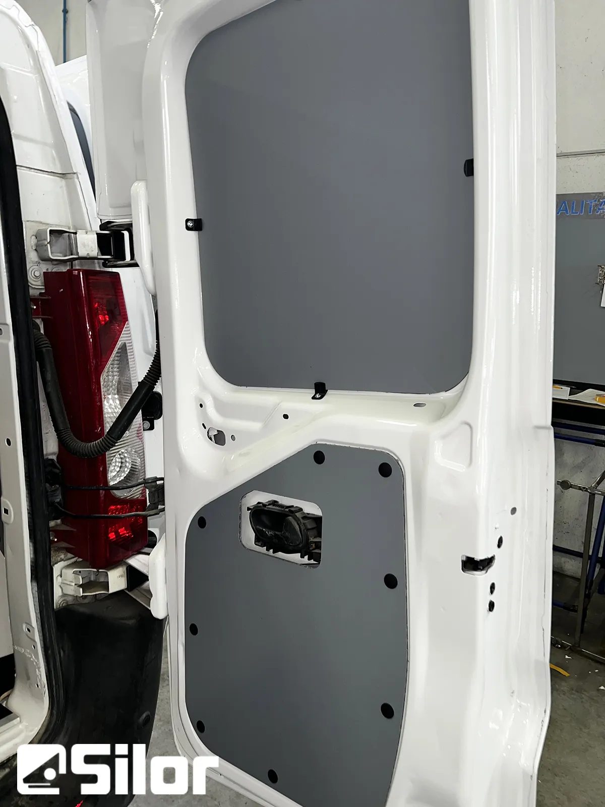 Porta furgone imbiancata con pannello grigio.