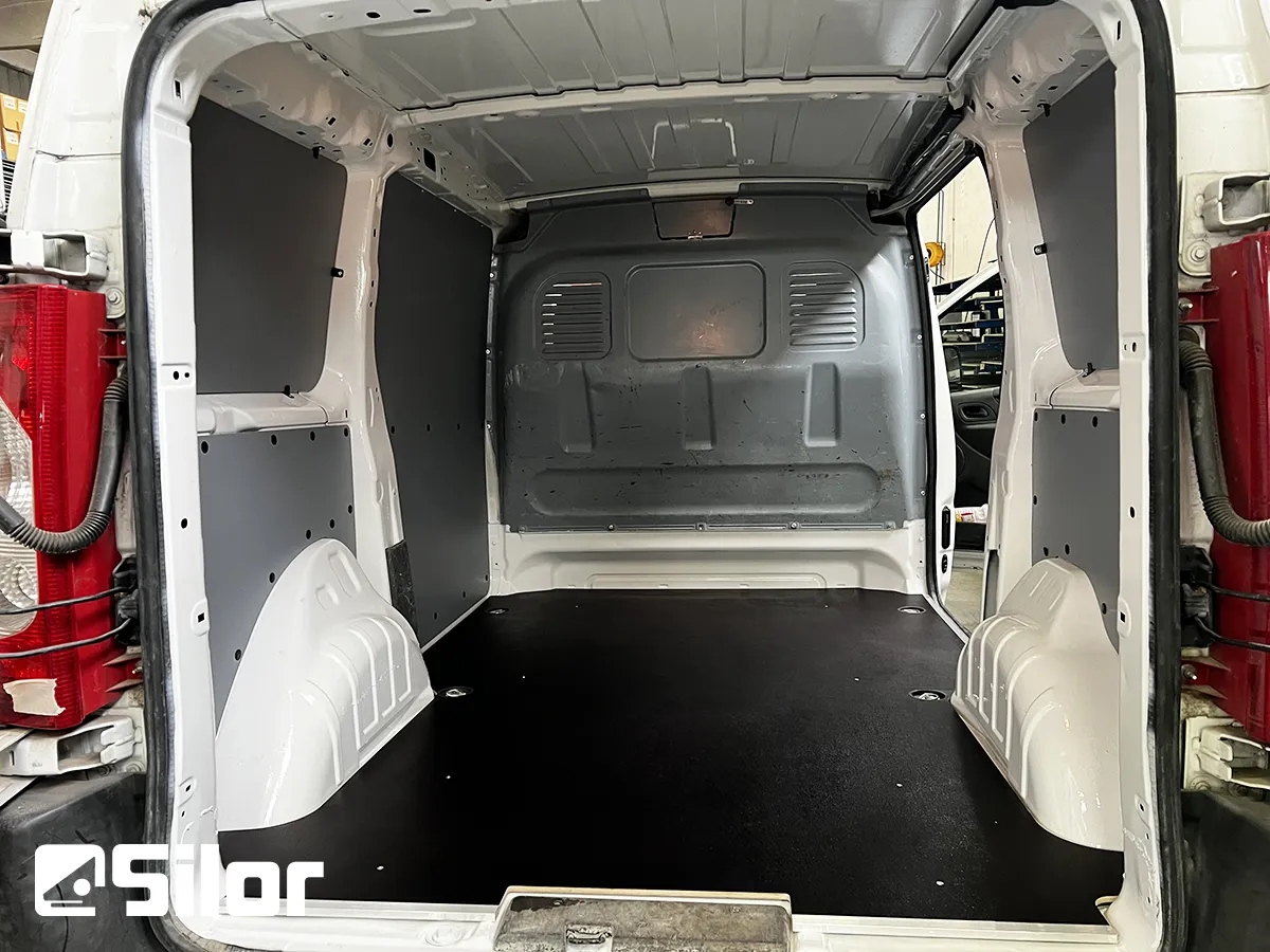 Interno di un furgone commerciale bianco con rivestimento protettivo.