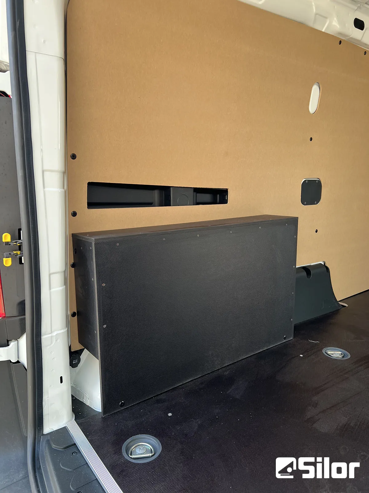Interno di un furgone con rivestimento in legno e scatola nera.