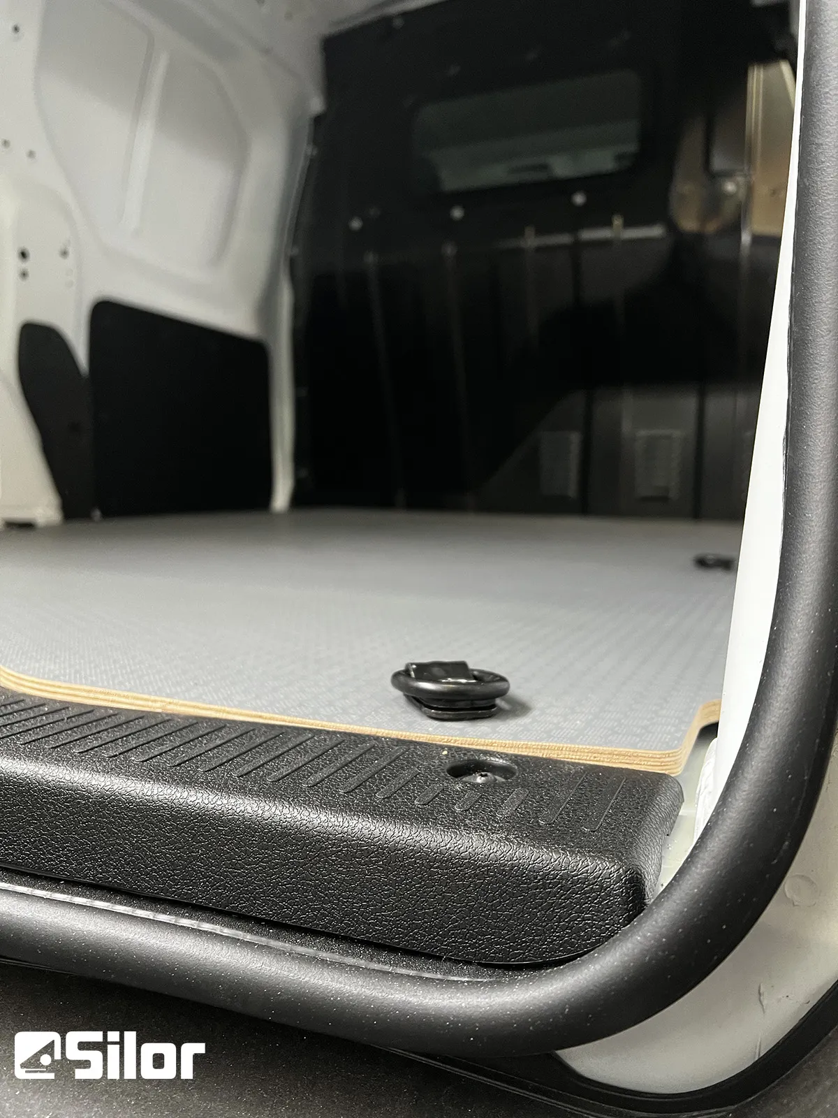 Interno di un furgone cargo con pavimento rivestito.