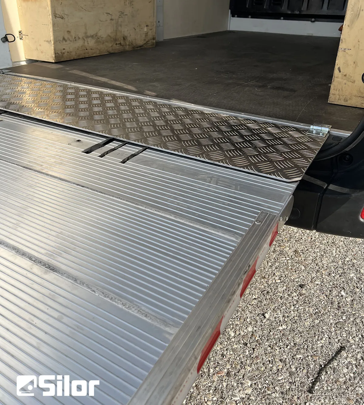 Rampa di carico di un furgone con logo Silor in basso a sinistra.