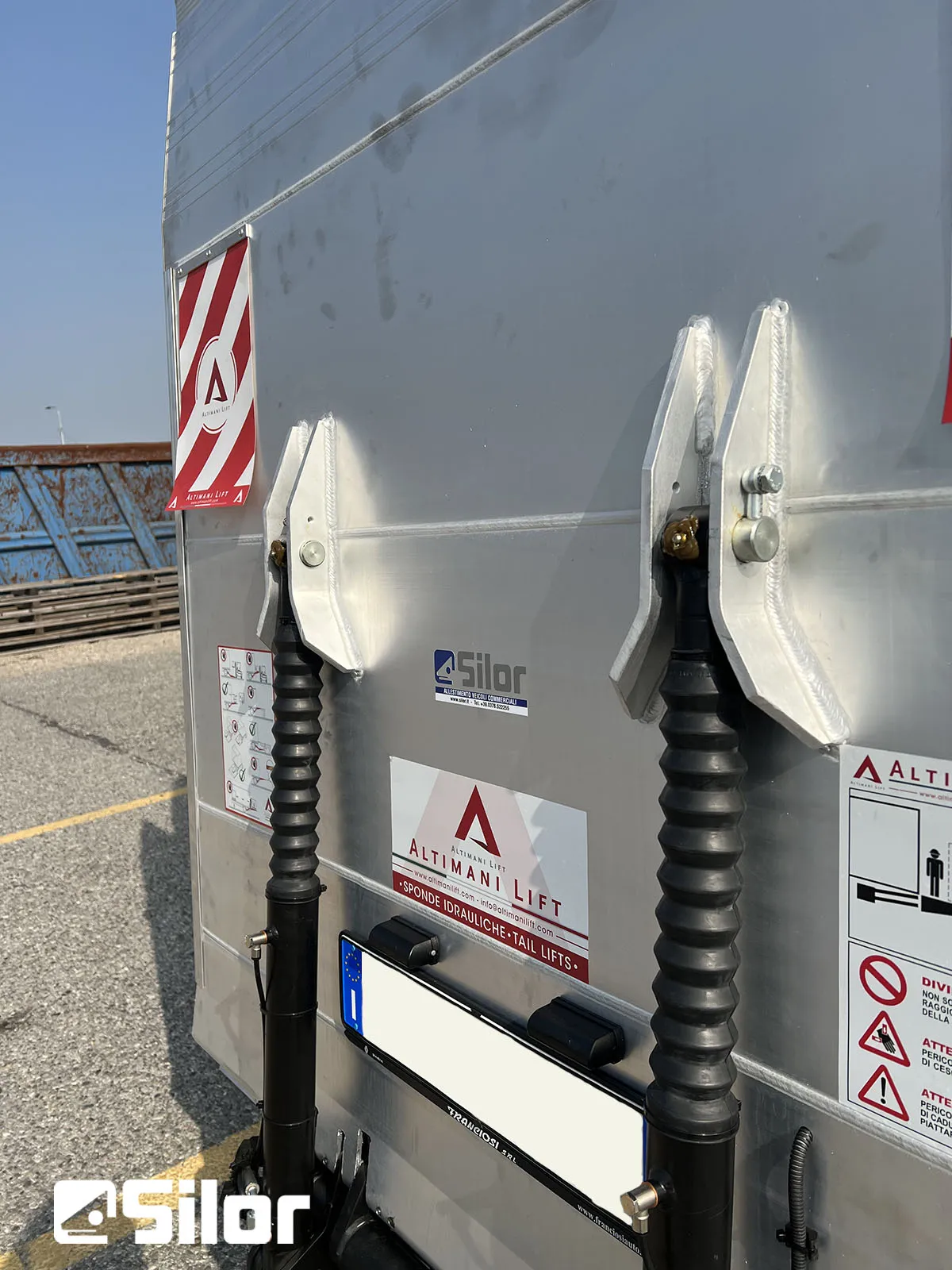 Vista ravvicinata delle gambe di sostegno di un camion con i marchi del produttore.