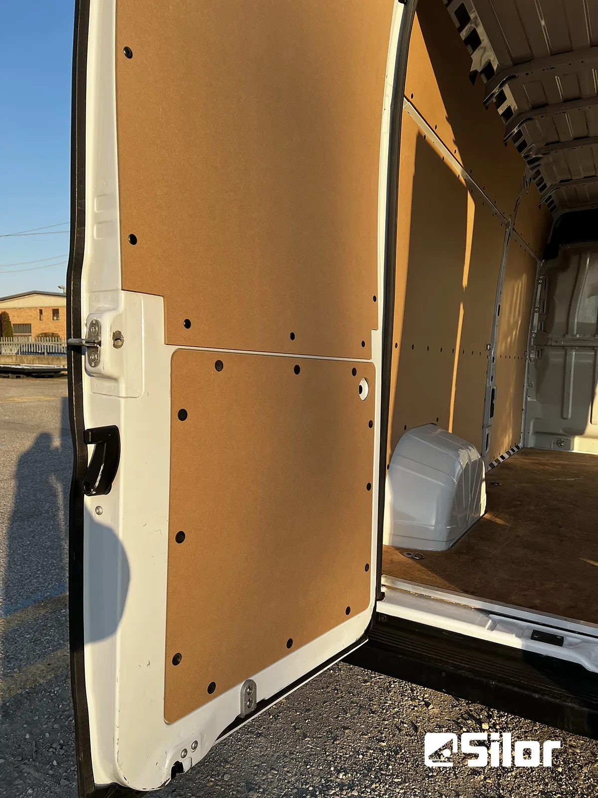 Interni di furgone con rivestimenti in legno chiaro.