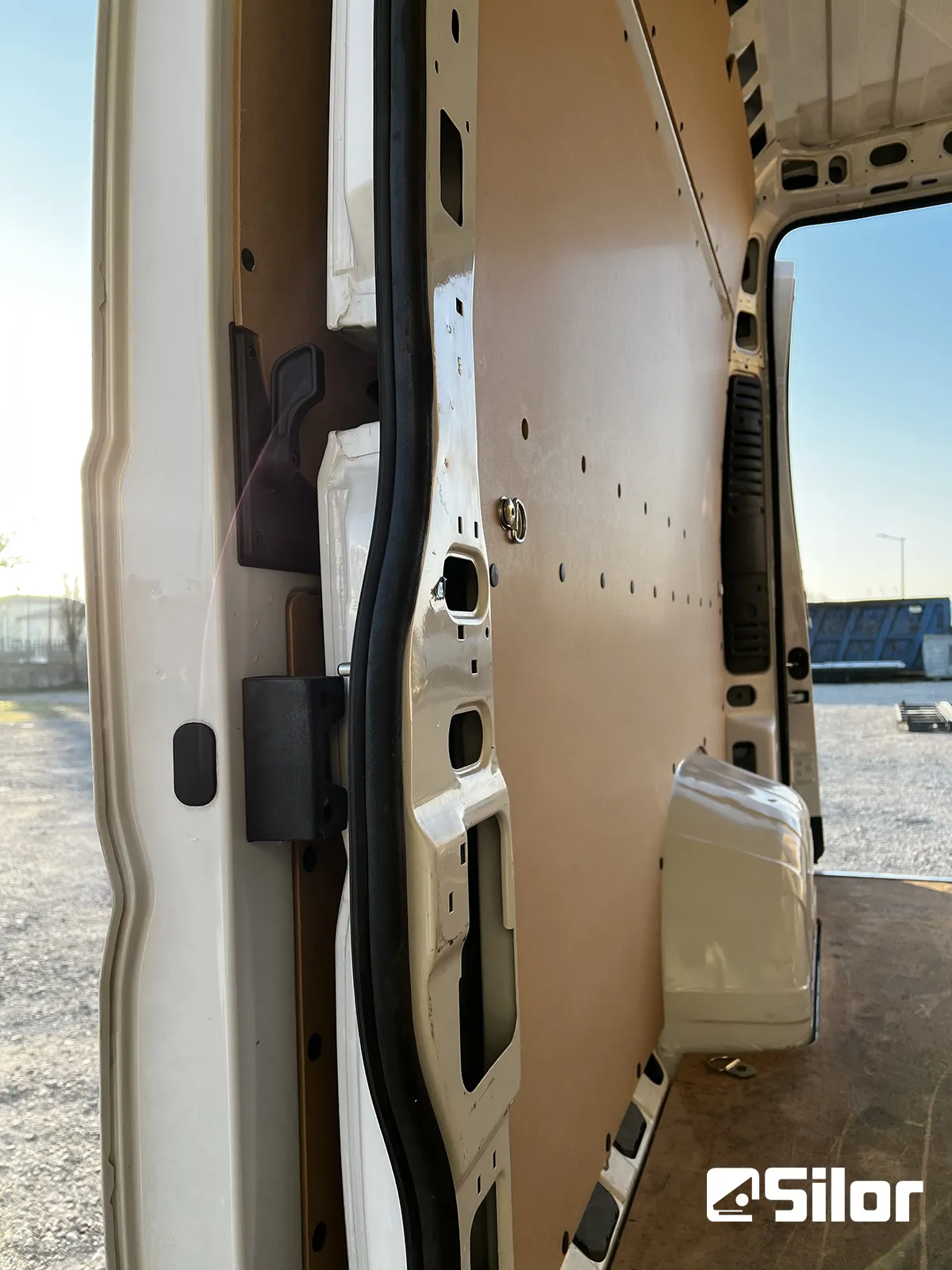 Interni di un furgone bianco con rivestimento in legno.