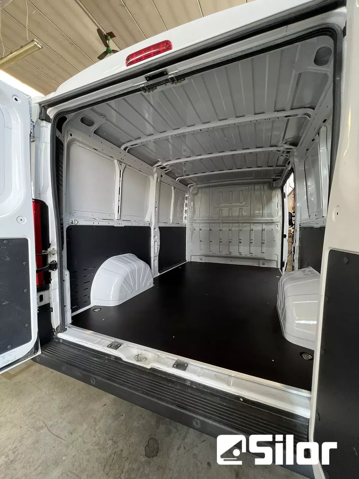 Interno spazioso e immacolato di un furgone bianco.