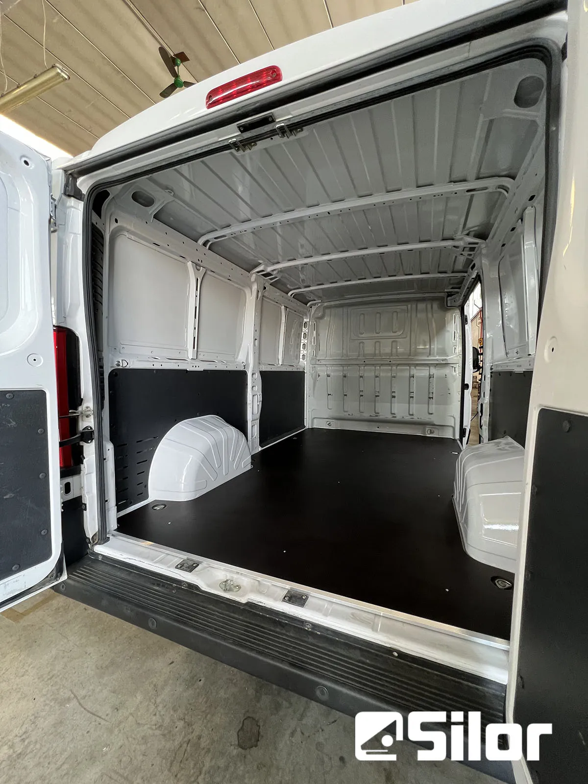 Interni spaziosi e ben organizzati di un furgone bianco.