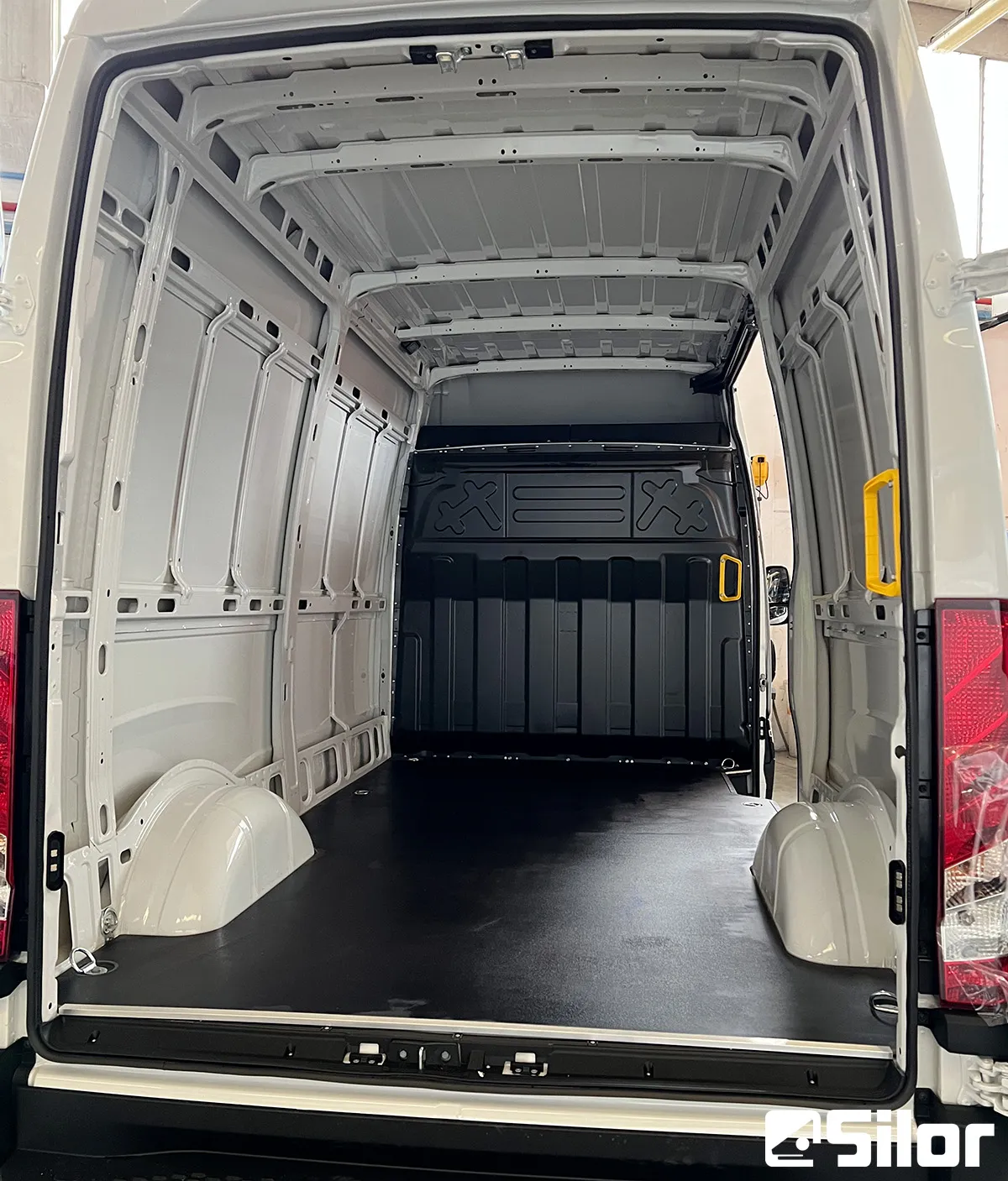 Interni di furgone bianco con rivestimento nero.
