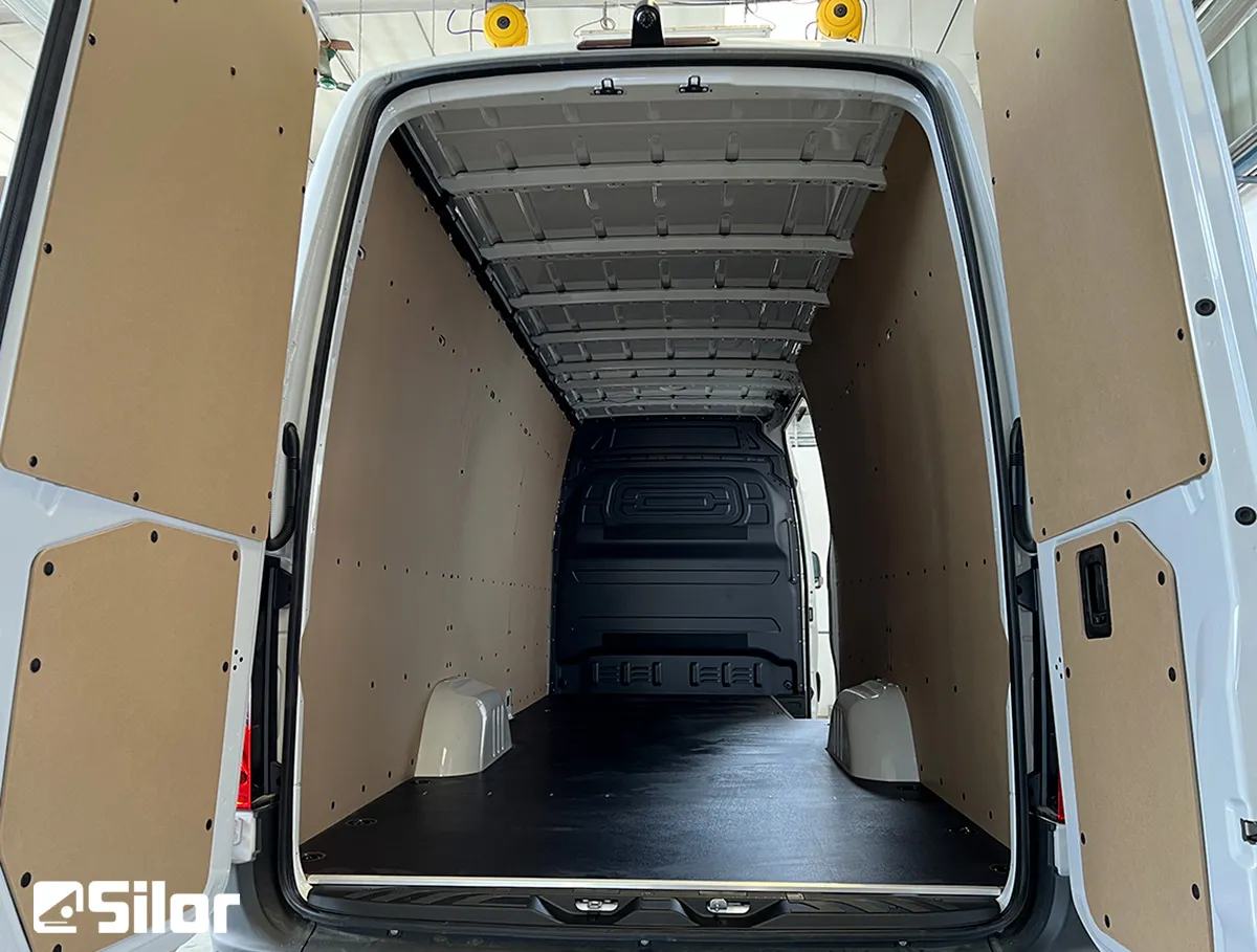 Interni di furgone cargo bianco con scaffalature interne in legno.
