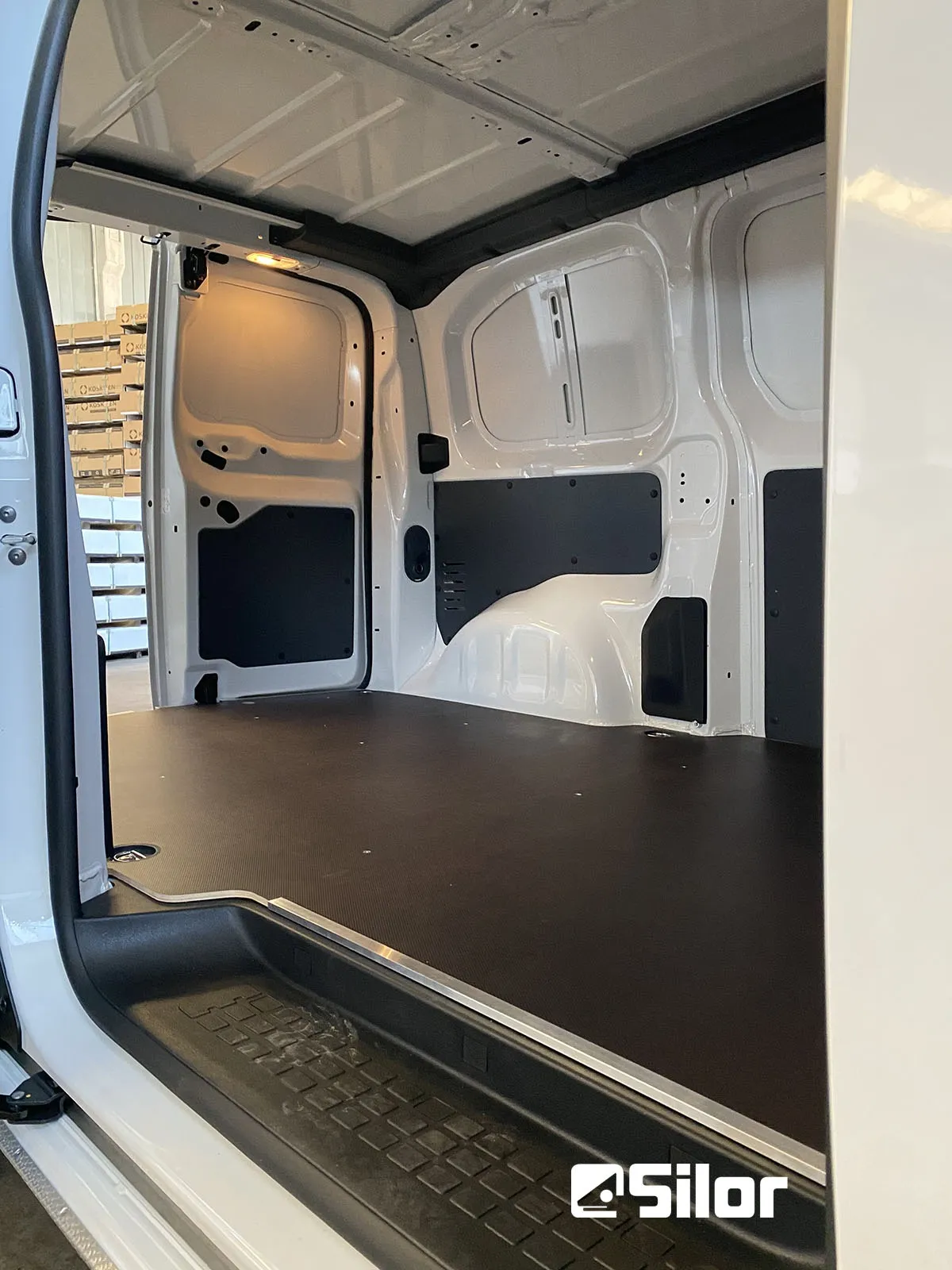 Interno di un furgone commerciale con rivestimento protettivo scuro.