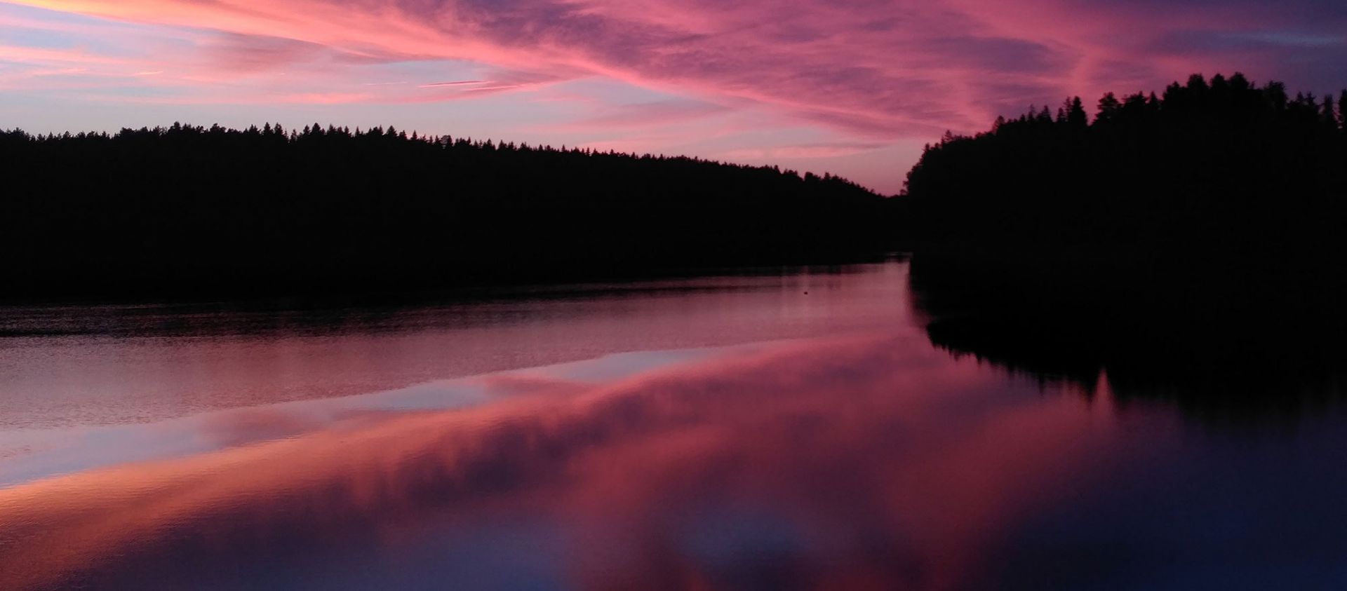 Auringonlasku suomalaisessa järvimaisemassa.