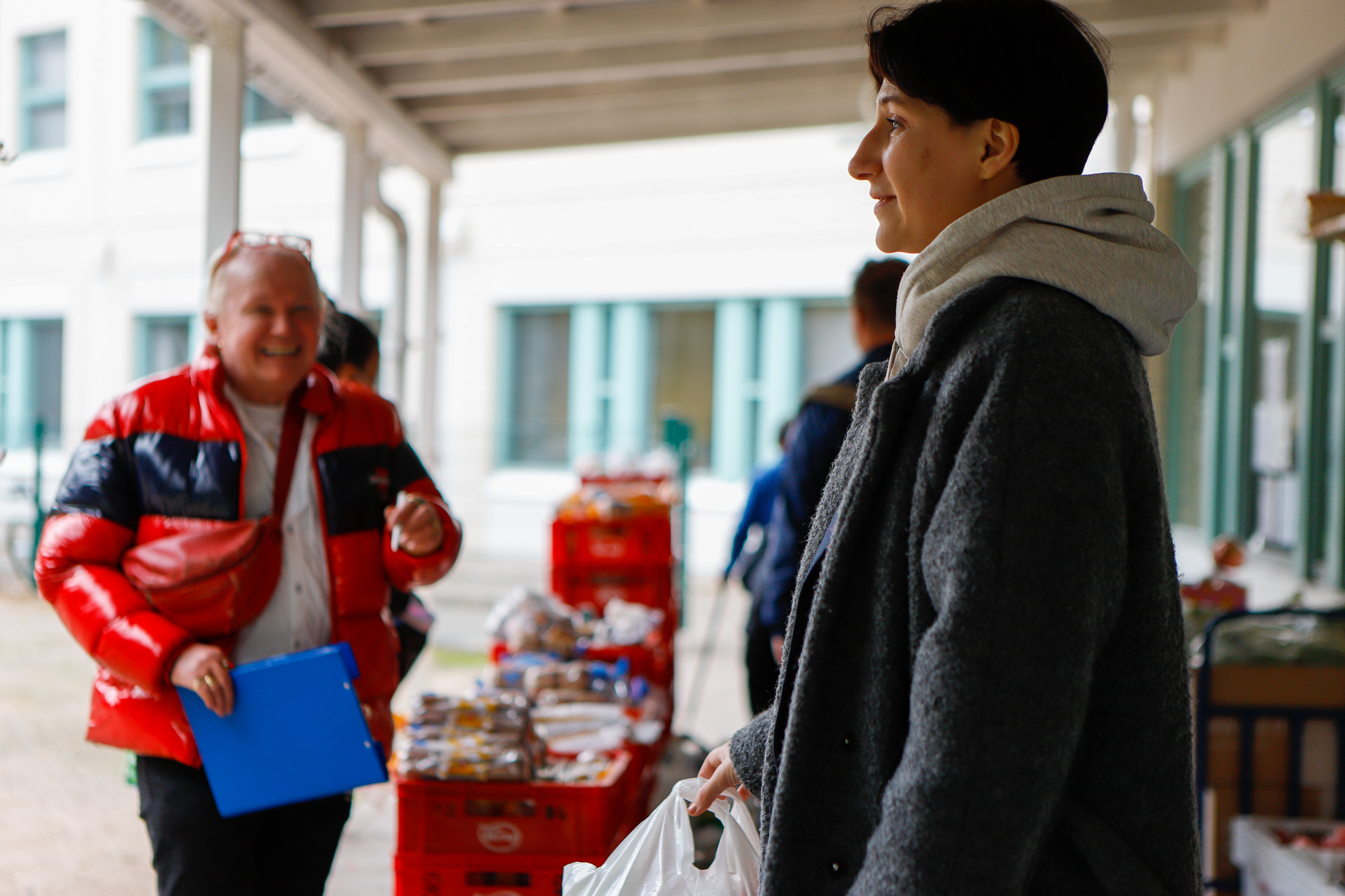 Ulkotila. Vasemmalla on mies, jonka toppatakki on auki ja oikealla on lyhythiuksinen nainen.