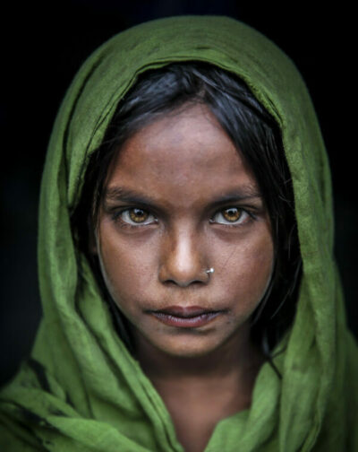 Bangladesilainen tyttö vihreä huivi päässä. Keskittynyt ilme.
