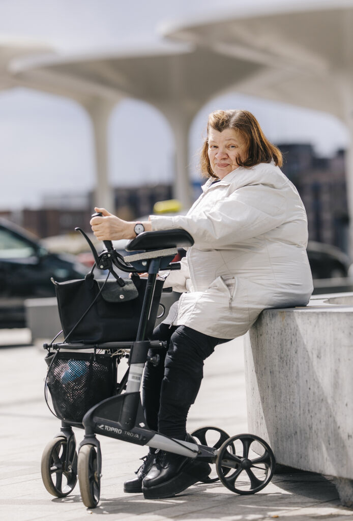 Pirkko istuu ulkona rollaattori vieressään